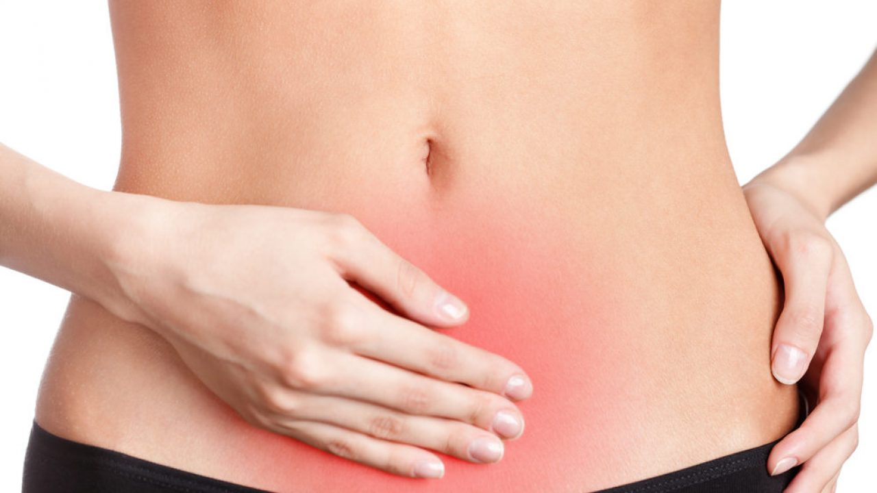 mulher com a mão na região do útero